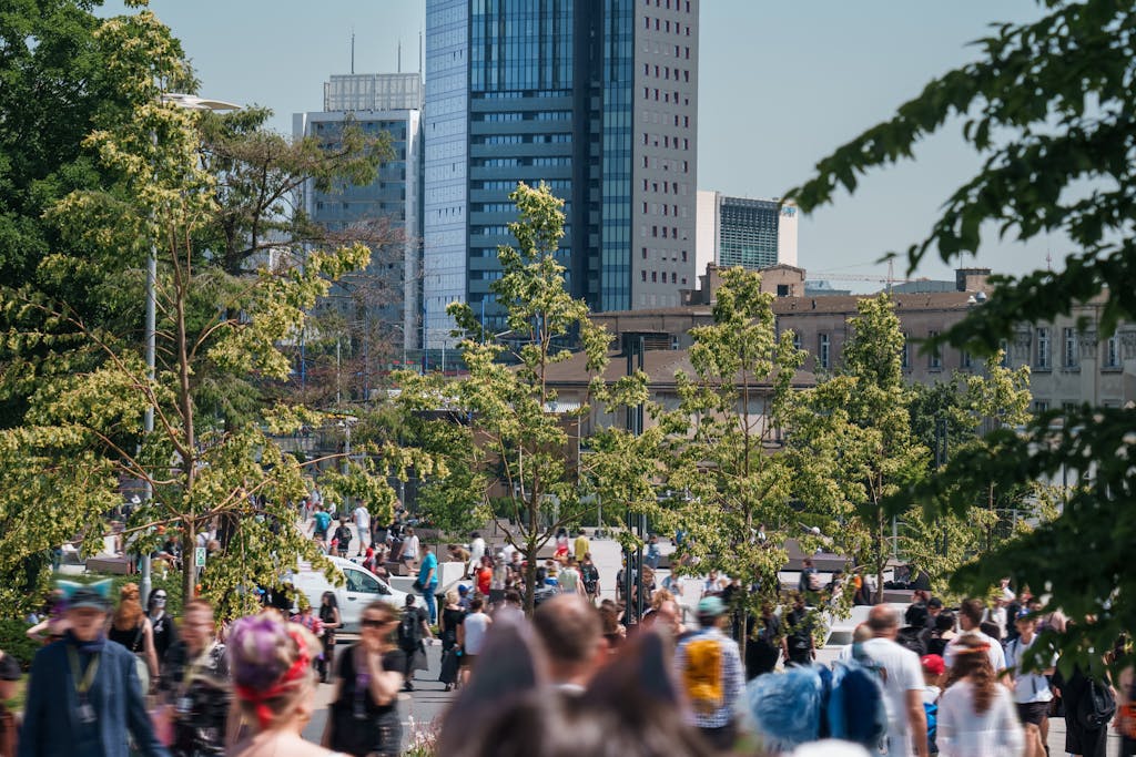 Vibrant crowd enjoying Pyrkon convention in urban Poznań with skyscrapers lining the skyline.